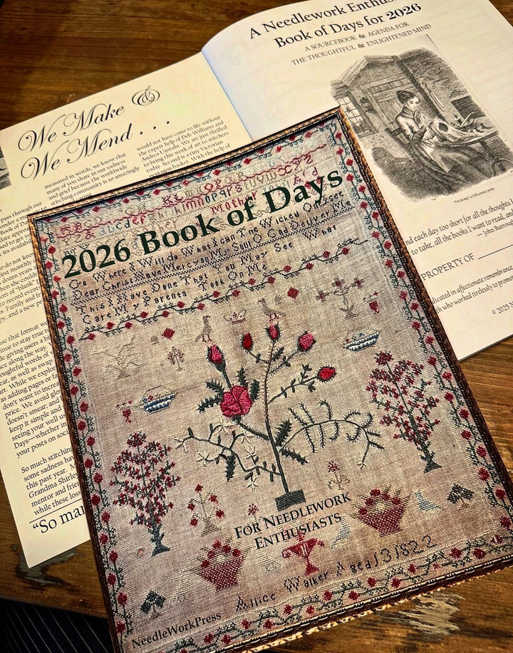 2026 Book of Days with needlework designs on a wooden surface