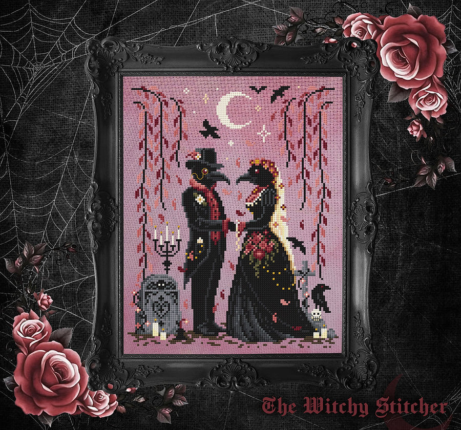 A framed gothic needlepoint or cross-stitch design featuring a couple in black attire under a crescent moon, with bats, hanging leaves, candles, and a tombstone on a pink background. The frame is ornate black, and the image is surrounded by dark decorative background elements including roses, cobwebs, and the text 'The Witchy Stitcher' at the bottom.