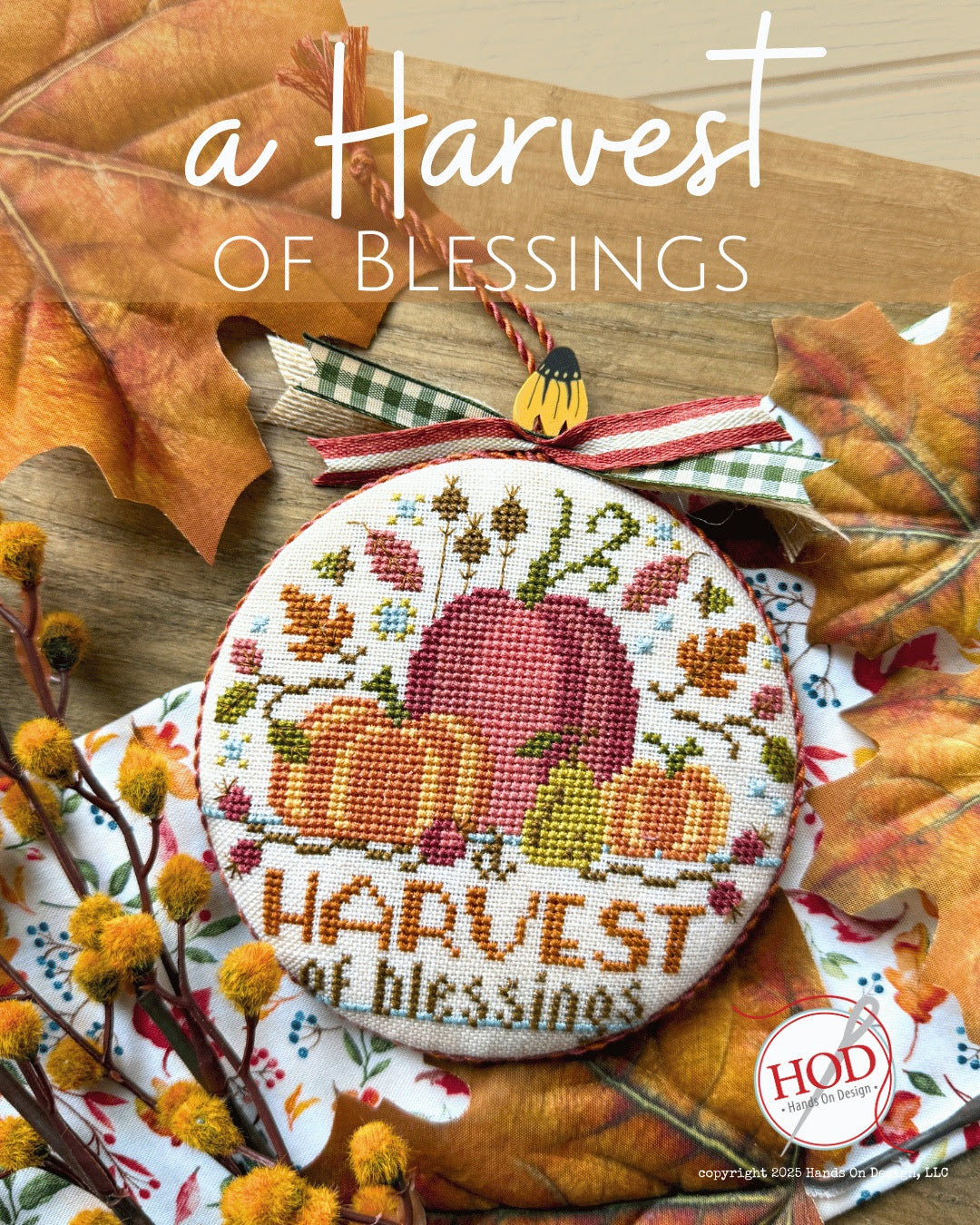 Cross-stitched design with 'Harvest of Blessings' text surrounded by autumn leaves and leaves.
