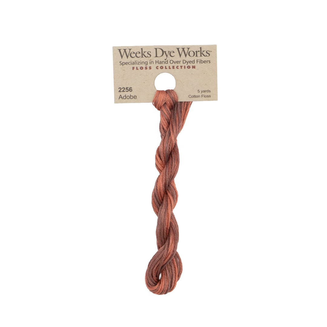 A single twisted bundle of Weeks Dye Works Floss Collection cotton thread in the shade Adaba, attached to a kraft paper header card.