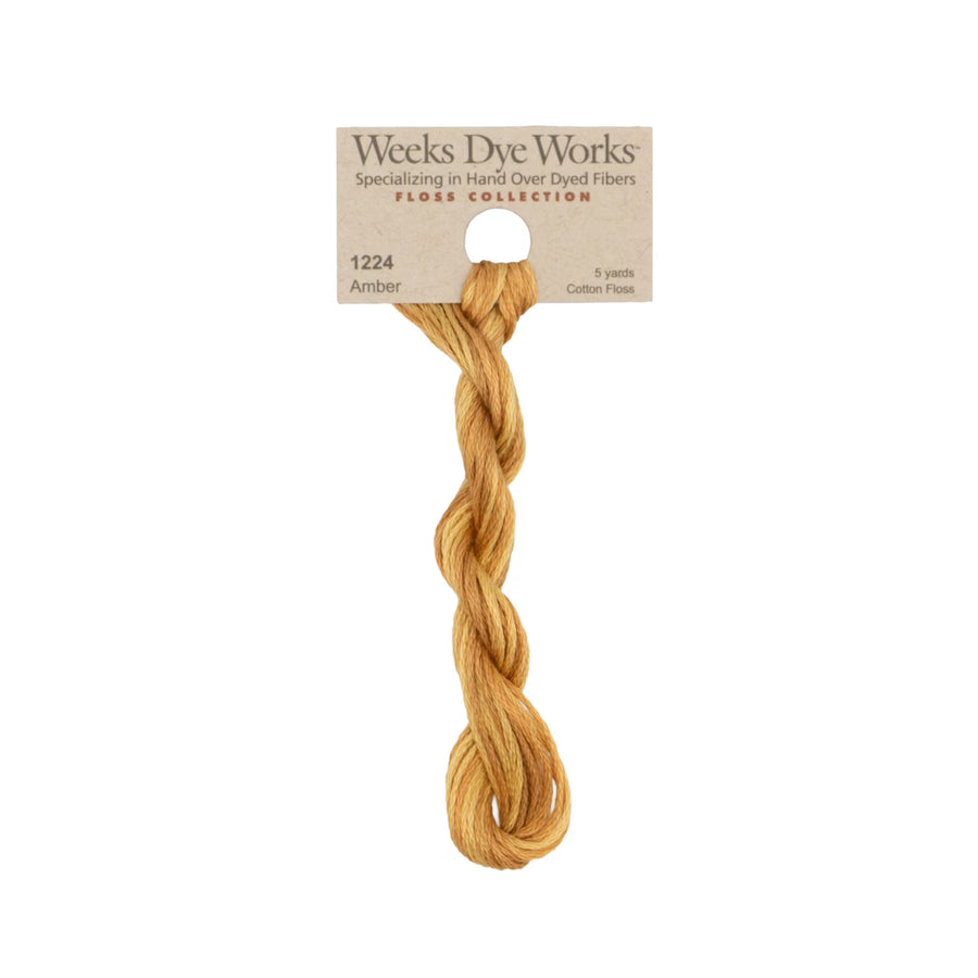 A single twisted bundle of Weeks Dye Works Amber cotton embroidery thread, attached to its original kraft paper header card, shown against a plain white background.