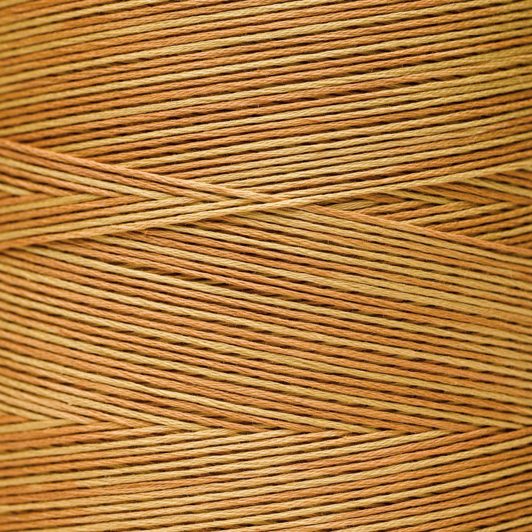 A close-up texture shot of tightly wound tan and light brown cord or thread, filling the entire frame.