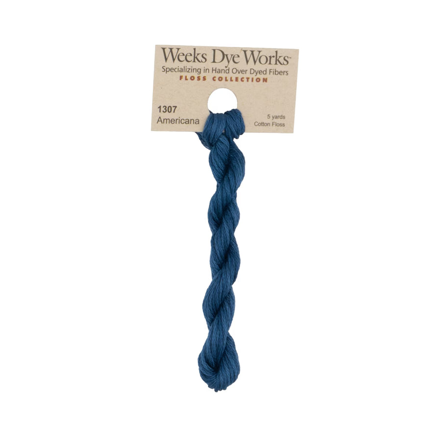 A single skein of Weeks Dye Works 'Americana' cotton flax yarn in a deep navy blue color, attached to its original kraft paper packaging label against a plain white background.
