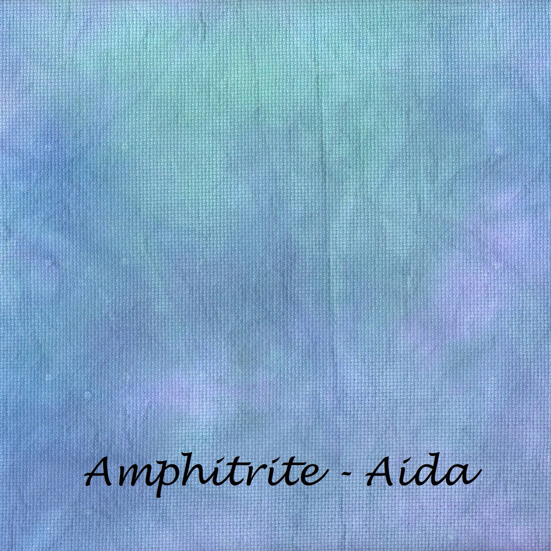A square fabric swatch with a mottled, tie-dye-like texture in shades of light blue, lavender, and mint green, with the text 'Amphitrite - Aida' printed in black at the bottom.