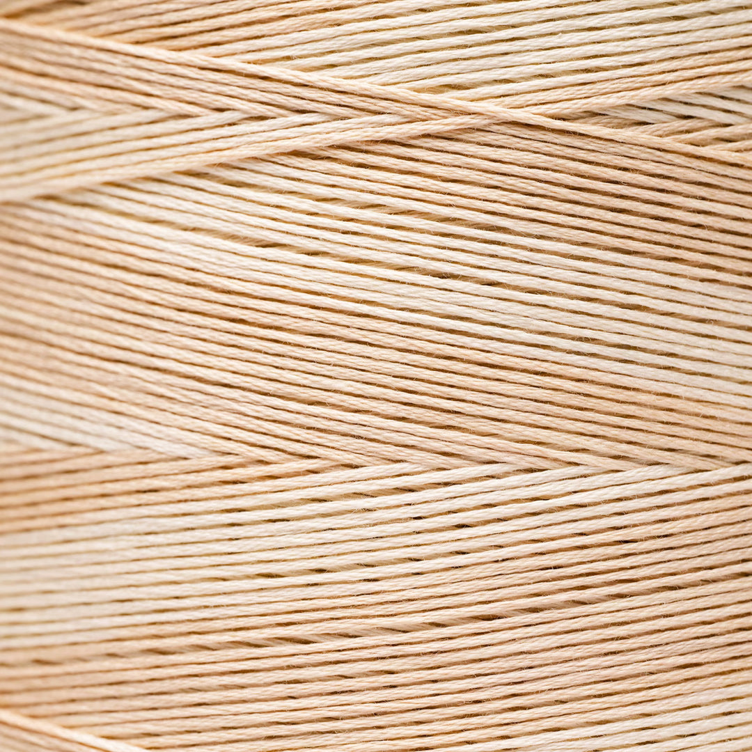 A close-up texture shot of light beige braided thread or cord, showing the fine strands woven in a diagonal pattern.