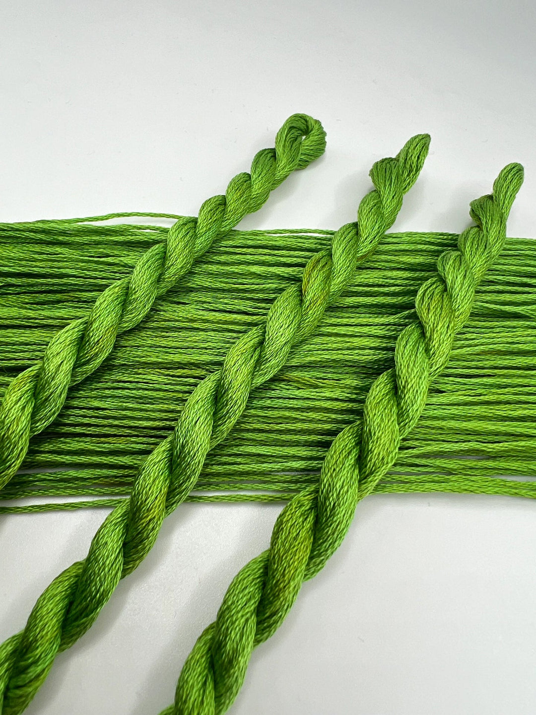 Green embroidery floss on a white background