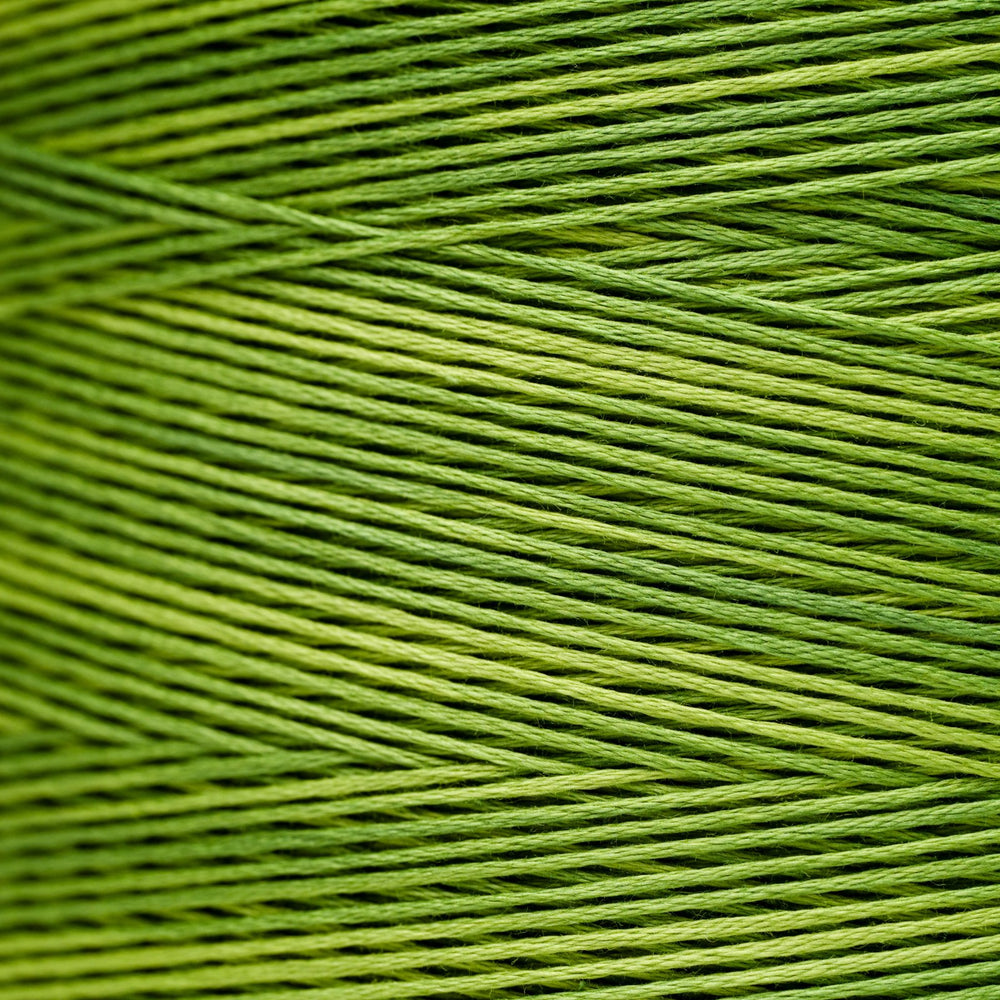 A close-up of bright olive green embroidery thread wound in parallel diagonal rows.
