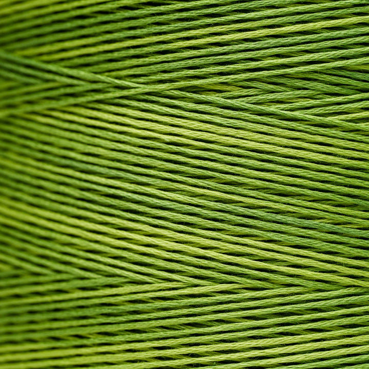 A close-up of bright olive green embroidery thread wound in parallel diagonal rows.