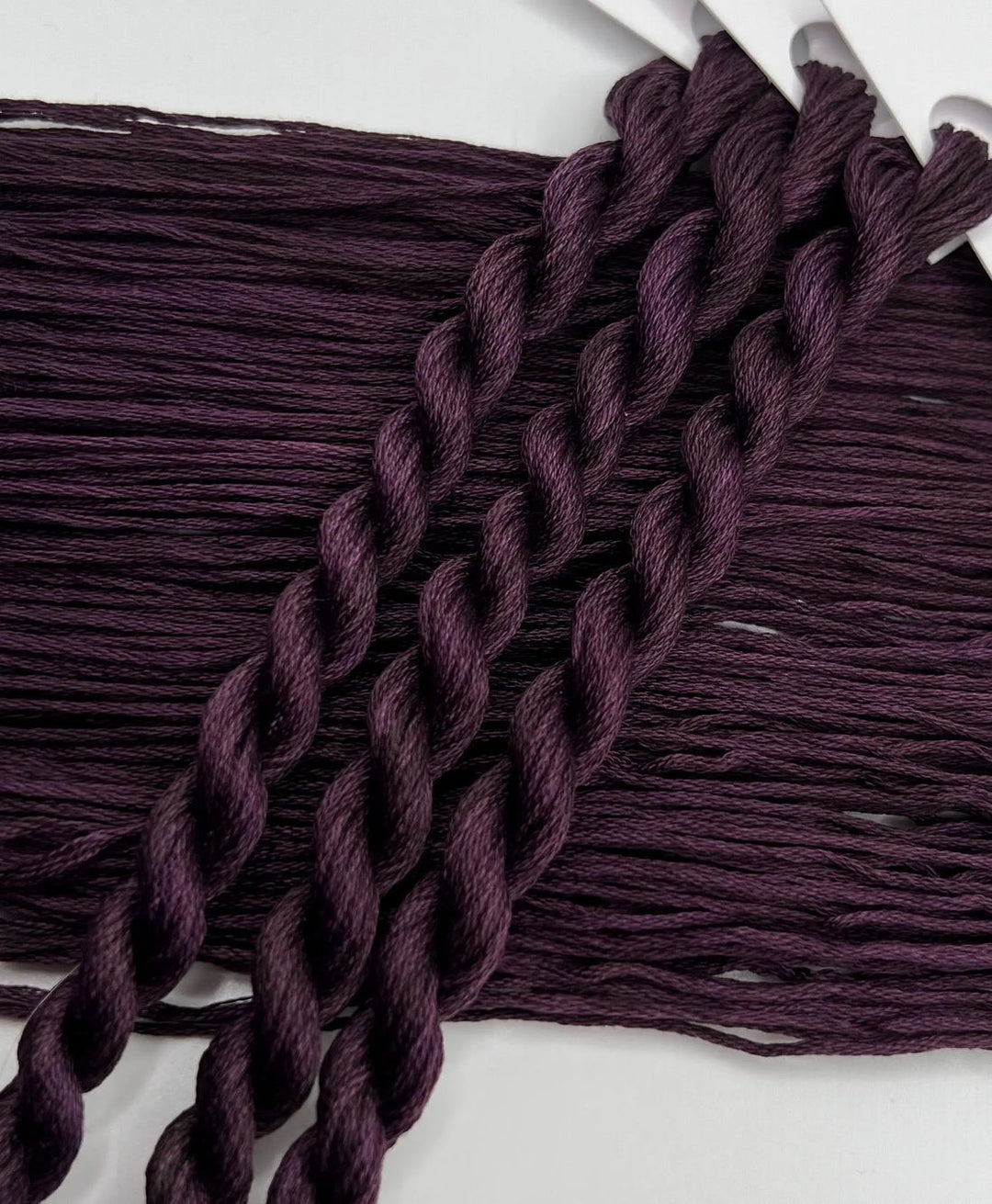 Close-up of braided purple yarn on a white background
