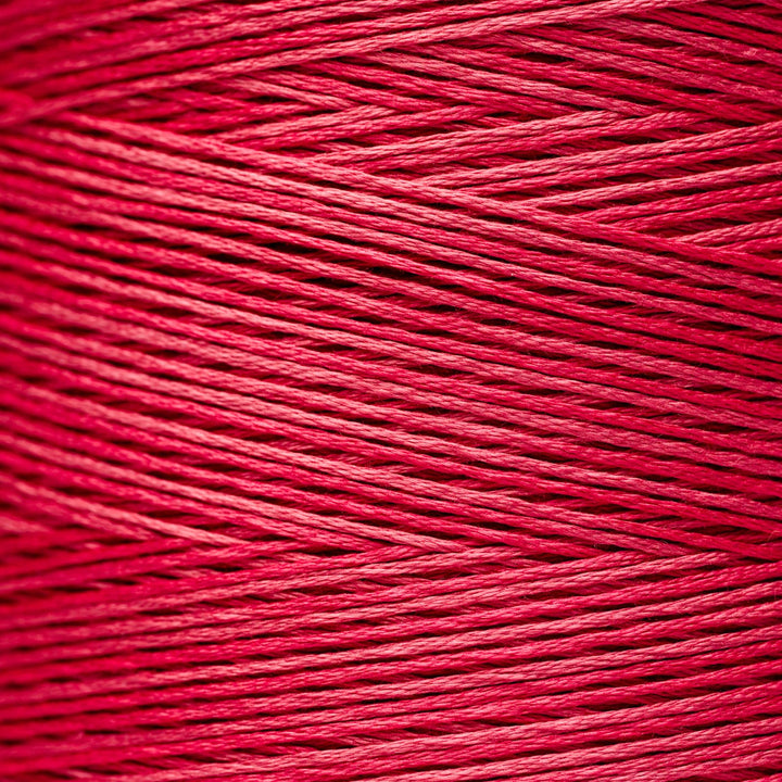 A close-up texture shot of bright pink floss yarn, showing the detailed twisted strands and color.