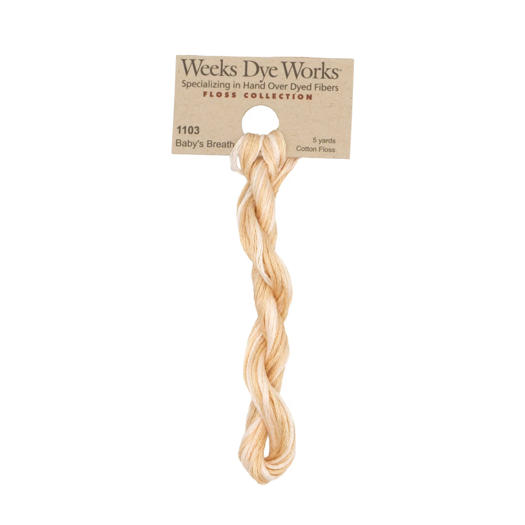 A 5-yard skein of Weeks Dye Works Baby's Breath cotton floss in a light peach-beige color, hanging from its original kraft paper packaging header card against a solid white background.
