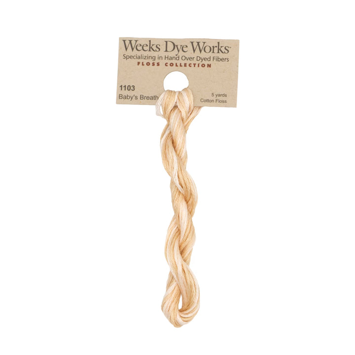 A 5-yard skein of Weeks Dye Works Baby's Breath cotton floss in a light peach-beige color, hanging from its original kraft paper packaging header card against a solid white background.