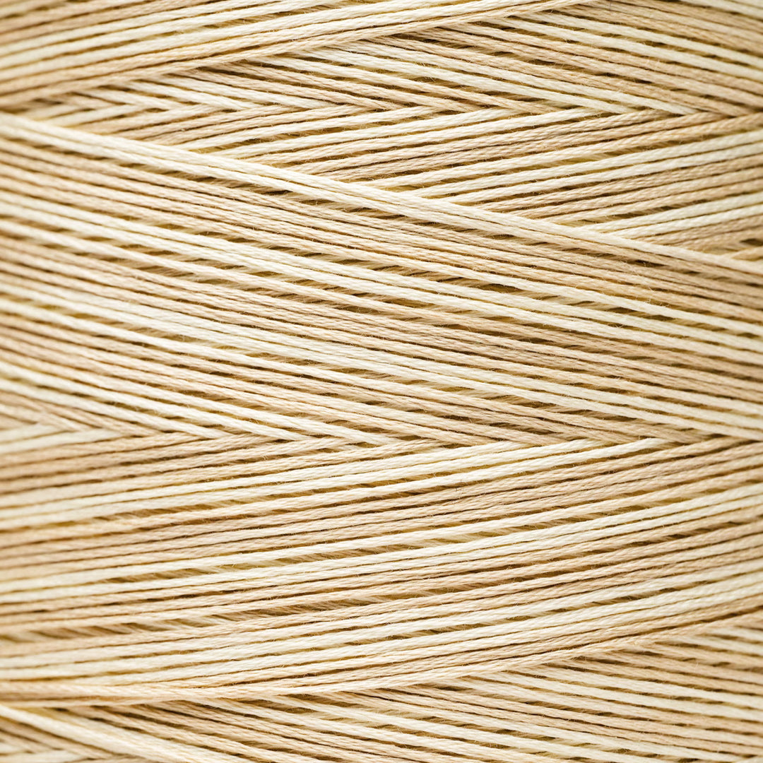 A close-up texture shot of light beige braided cord or thread, showing the fine strands woven in a diagonal chevron pattern.