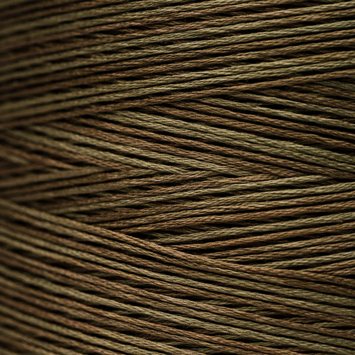 A close-up texture shot of multi-colored braided cord or thread, showing fine strands woven in a diagonal pattern. The color identity is a blend of olive green, brown, and dark brown, creating a muted earthy tone.