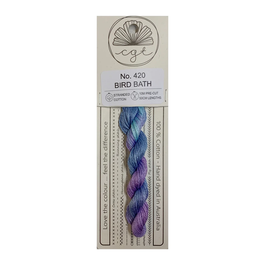 Packaged yarn with a purple and blue skein on a beige label with text and branding.