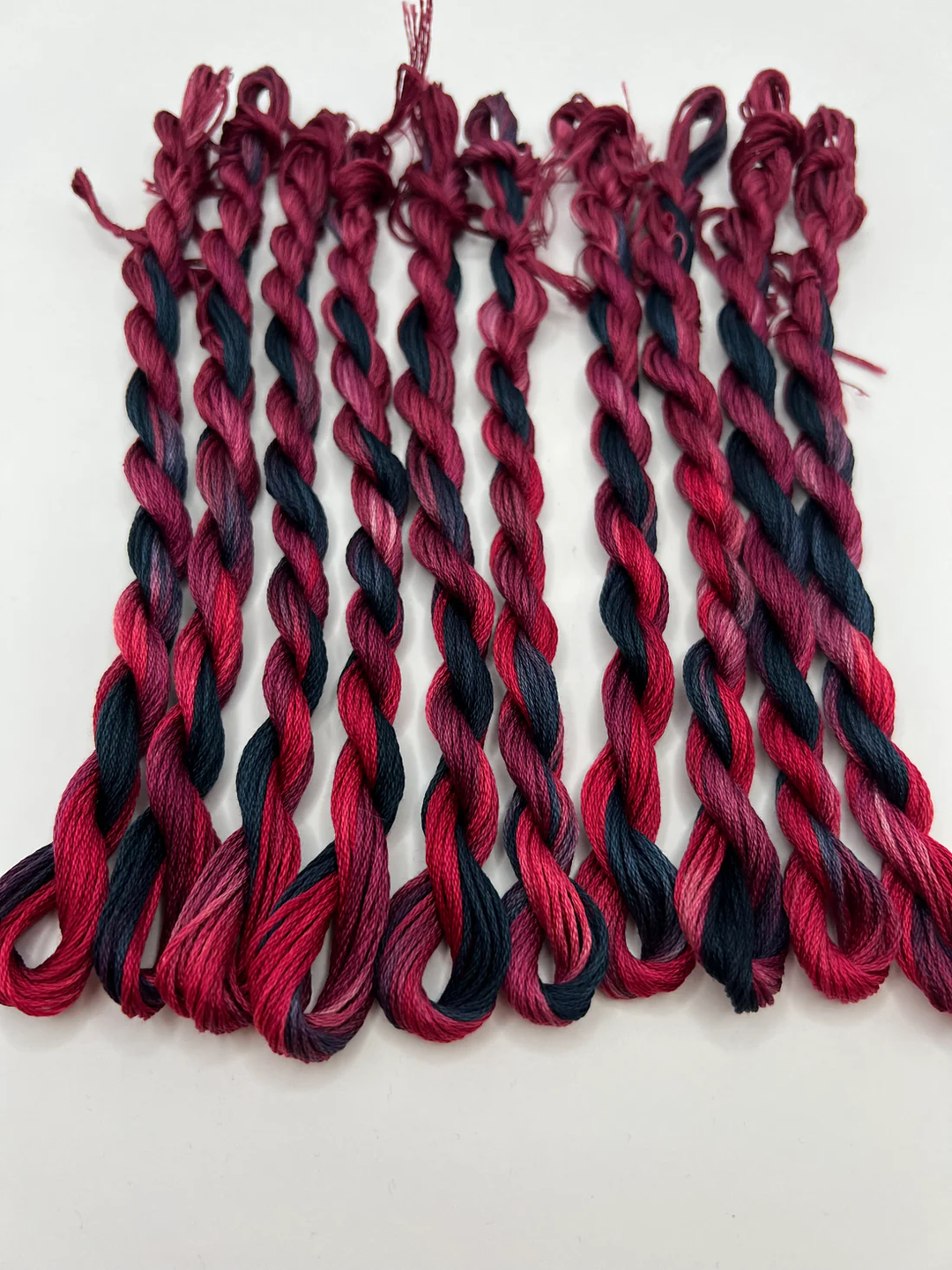 Red and black braided embroidery floss  on a white background