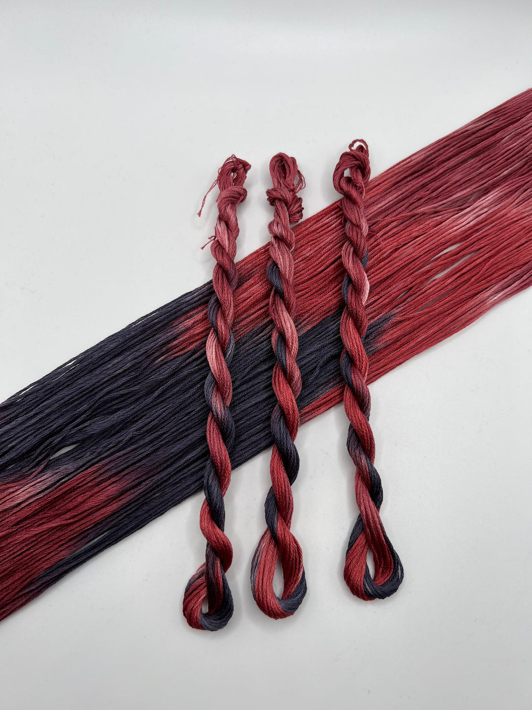 three braided floss skiens fo black and dark grey floss 