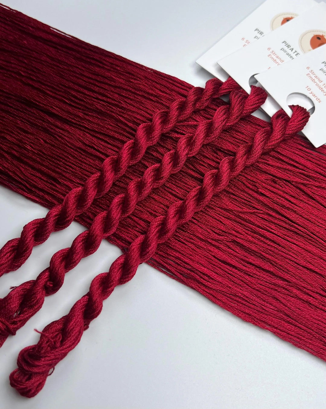 Red braided thread on a white background with product tags.