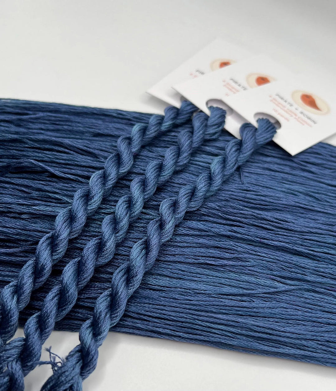 Blue thread with a packaging label on a white background