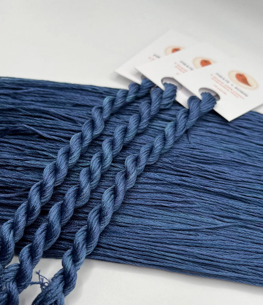 Blue thread with a packaging label on a white background