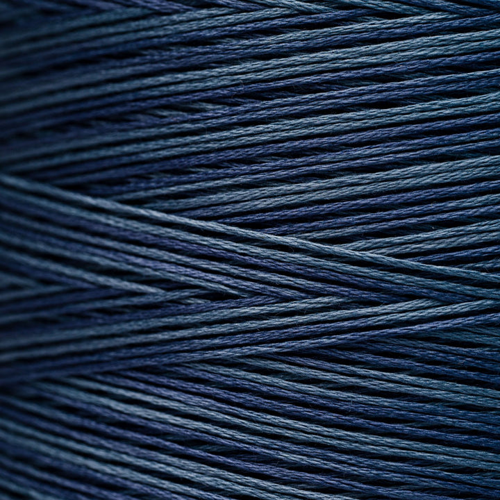 A close-up of tightly wound yarn strands in a deep navy blue color, showing the texture and sheen of the thread.