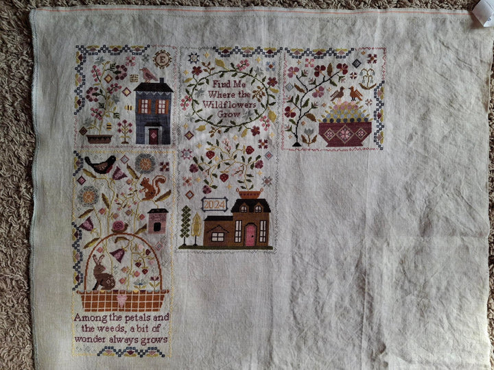 Embroidered fabric with decorative patterns and text on a textured surface