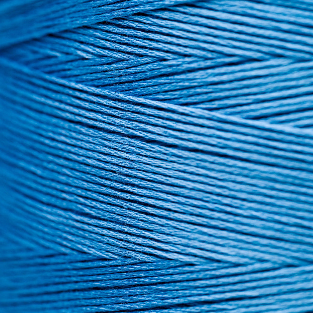 A close-up macro shot of tightly wound blue thread or yarn strands, filling the entire frame.