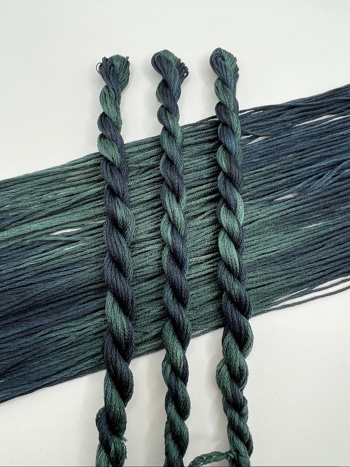 Three braided green skeins on a white background