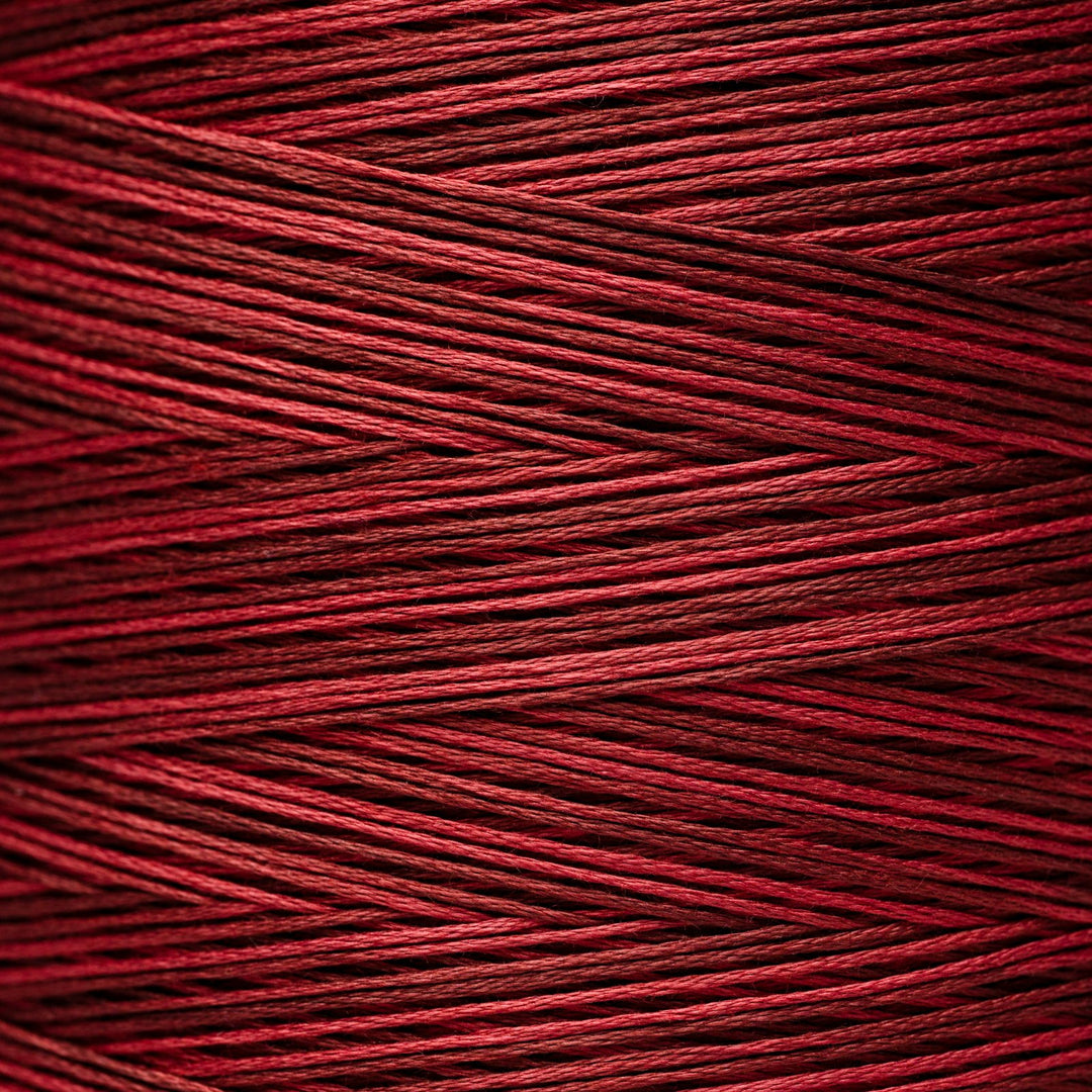 A close-up of tightly wound red thread or cord showing the texture and color of the material.