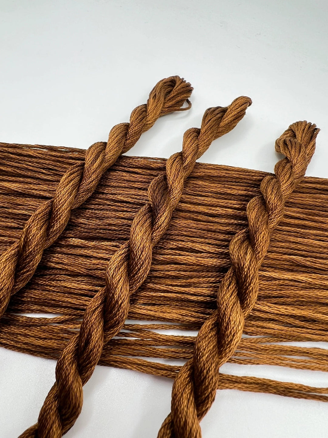 Close-up of brown braided thread on a white background