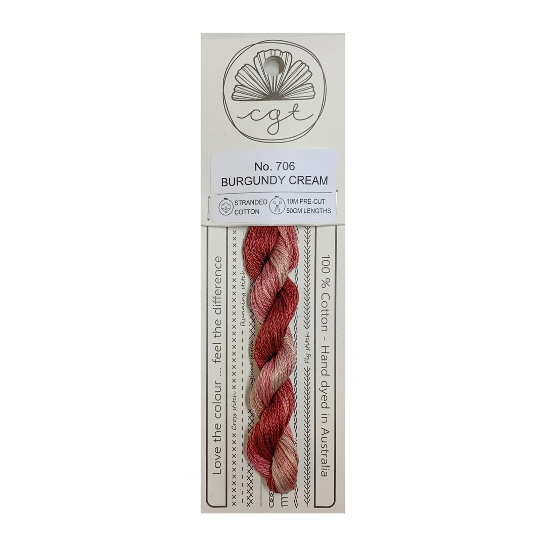 Packaged thread with a label indicating color 'Burgundy Cream' on a white background