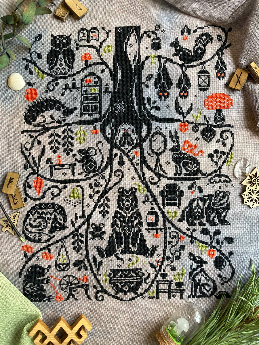 Cross-stitched pattern of a tree with animals on a textured fabric background