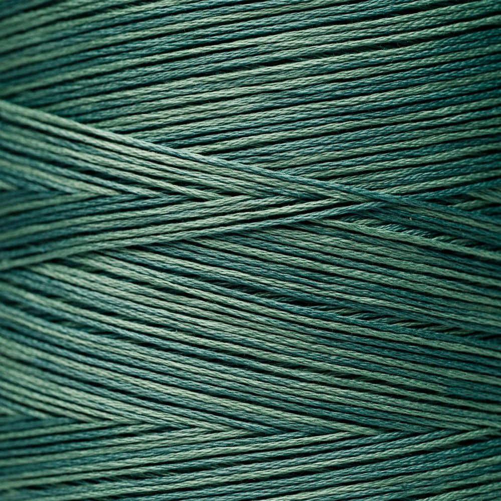A close-up of tightly wound dark teal-green cord or thread filling the frame, with diagonal strands crossing over each other.