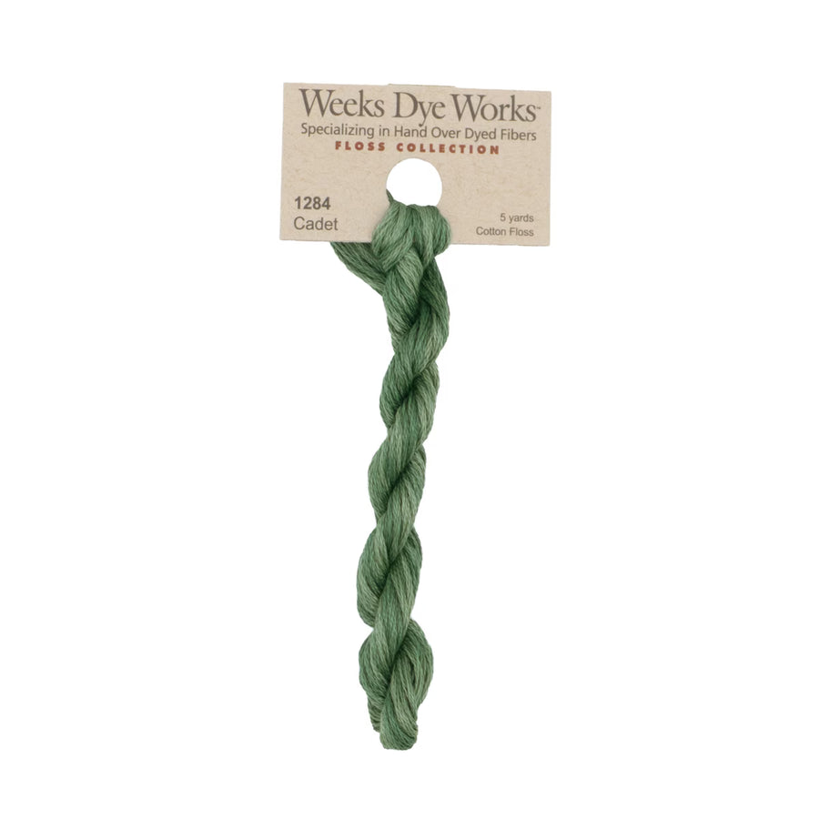 A 5-yard bundle of Weeks Dye Works Cadet cotton fiber in a sage green color, attached to its original kraft paper header card.