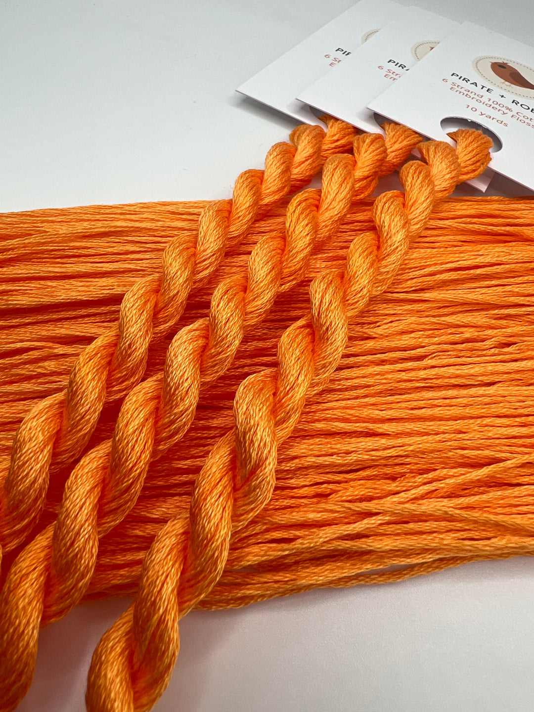 Orange embroidery floss with packaging on a white background