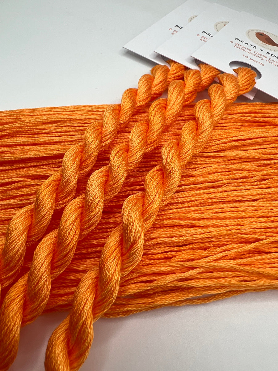 Orange embroidery floss with packaging on a white background