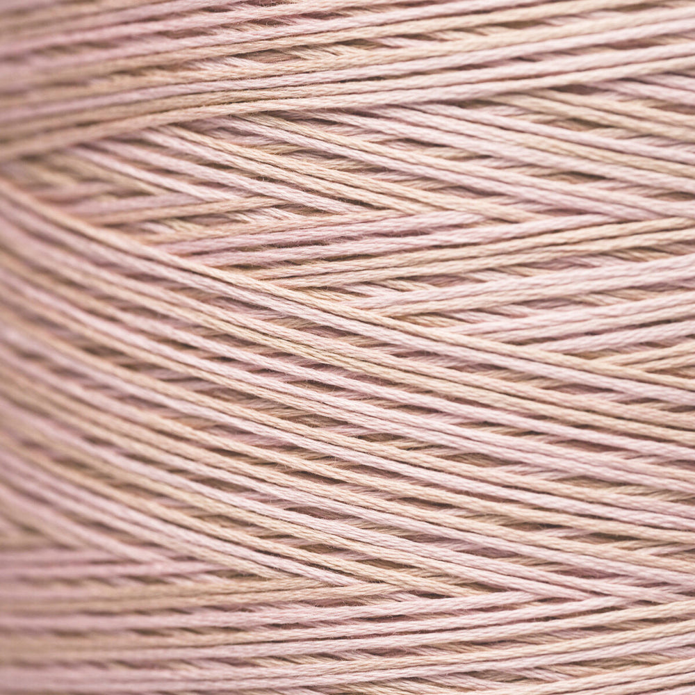 A close-up texture shot of fine yarn wound in a cone, showing the fine strands in a soft dusty pink color.