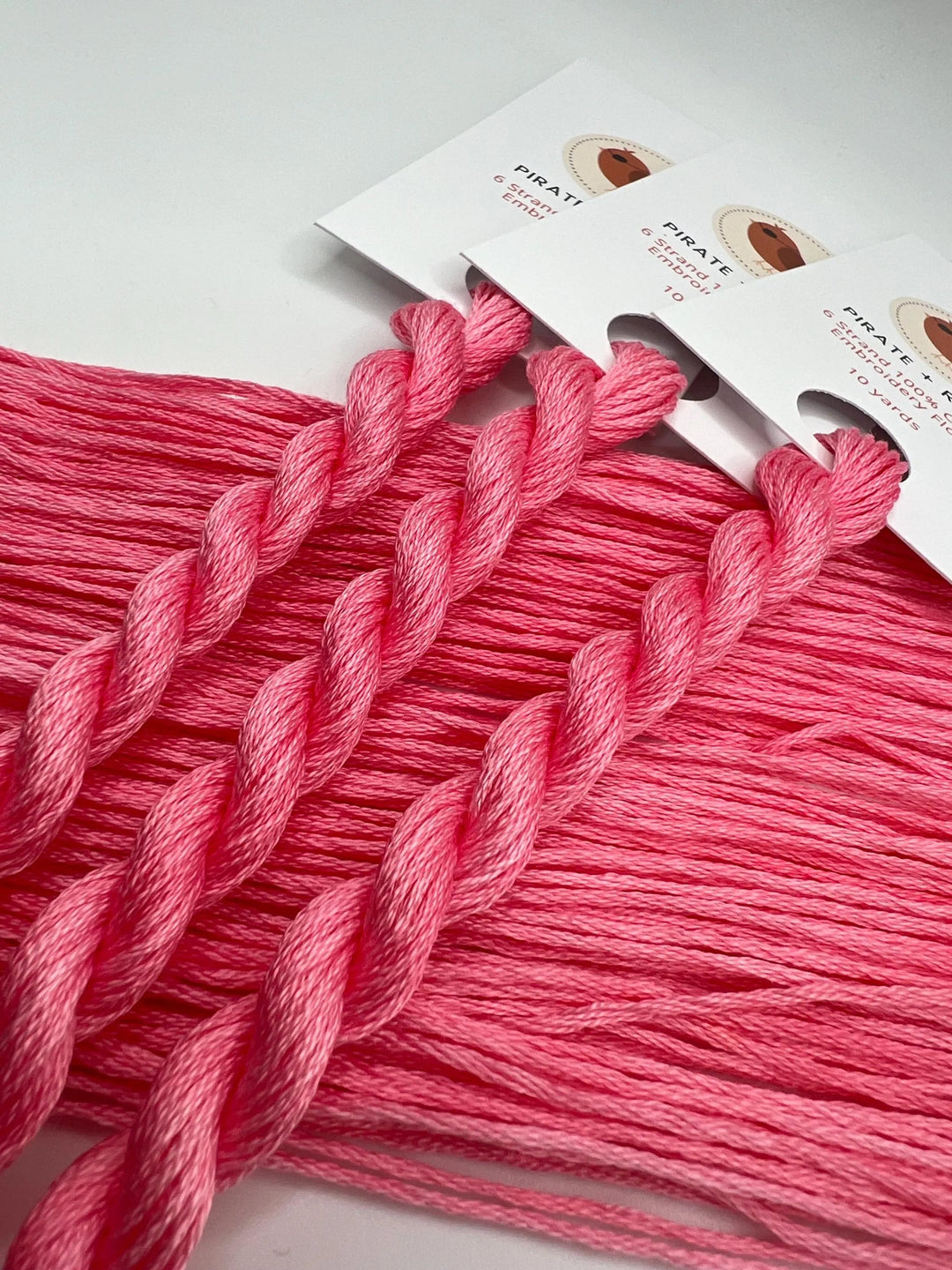 Pink embroidery floss with packaging on a white background