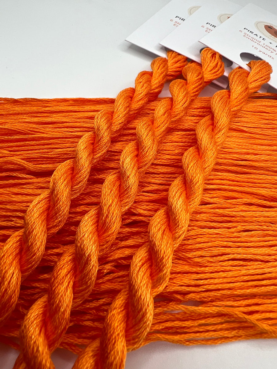 Orange embroidery floss with packaging on a white background