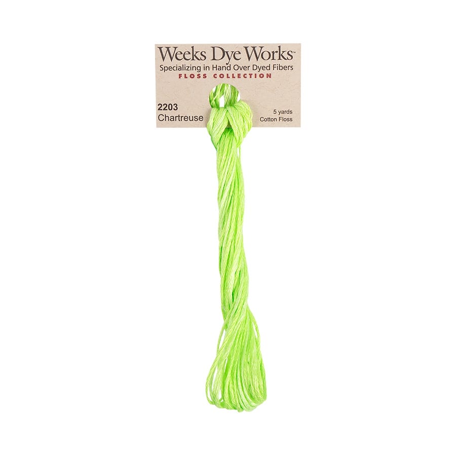 A bundle of bright chartreuse green cotton embroidery floss threads hanging from a paper header card labeled Weeks Dye Works.