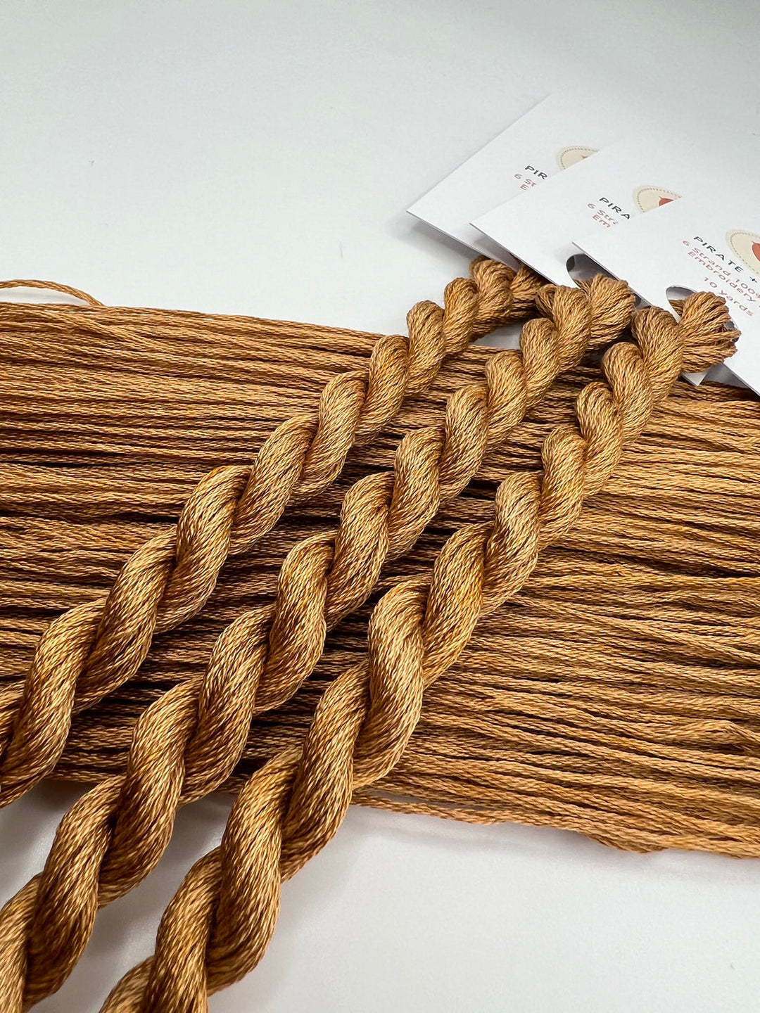 Brown braided hair extensions on a white background with a brand label.