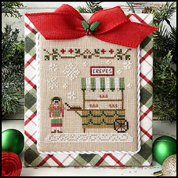 Decorative cross-stitched design of a crepe stand with a red bow on a plaid background.