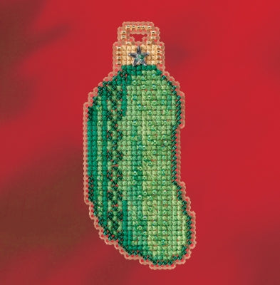 Cross-stitched pickle ornament on a red background