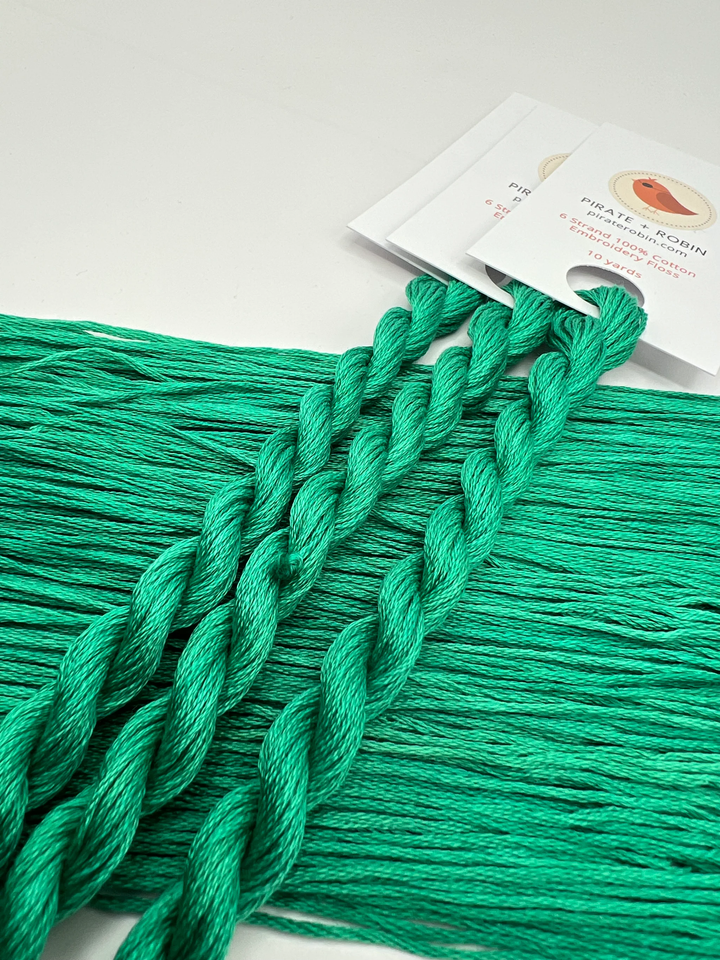 Green yarn with a brand label on a white background