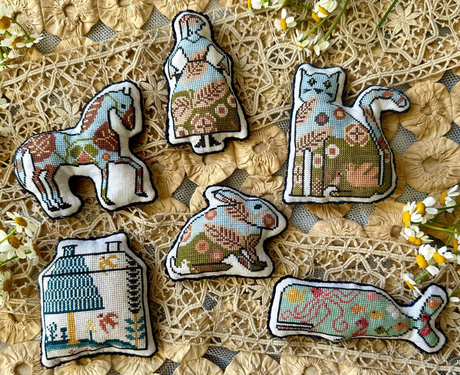 Set of embroidered animal patches on a textured fabric background