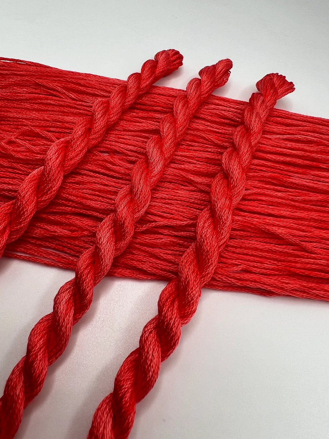 Red embroidery floss on a white background
