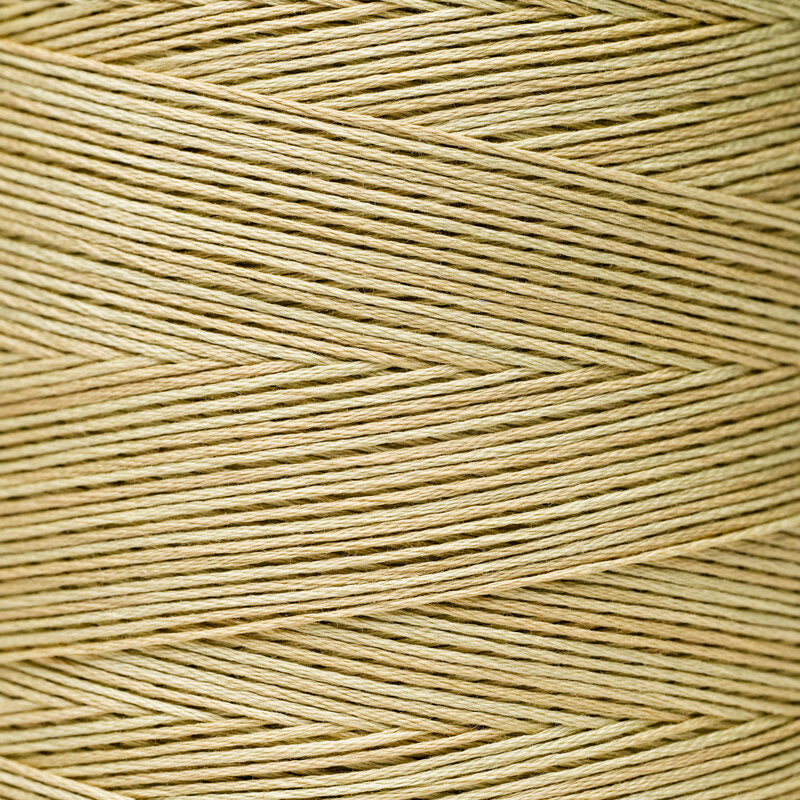 A close-up of tan or light beige thread wound as though around a spool 