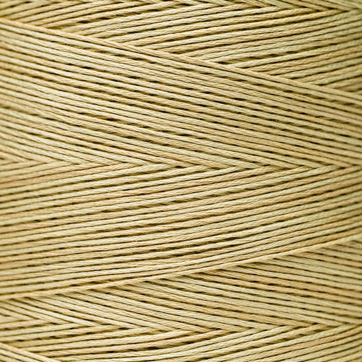 A close-up of tan or light beige thread wound as though around a spool 