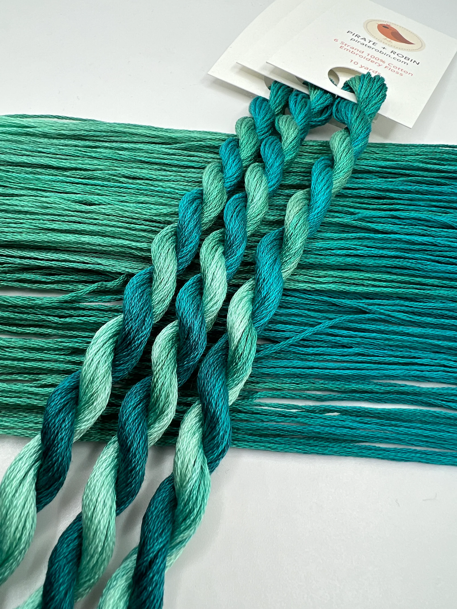 Braided teal yarn with a card on a white background