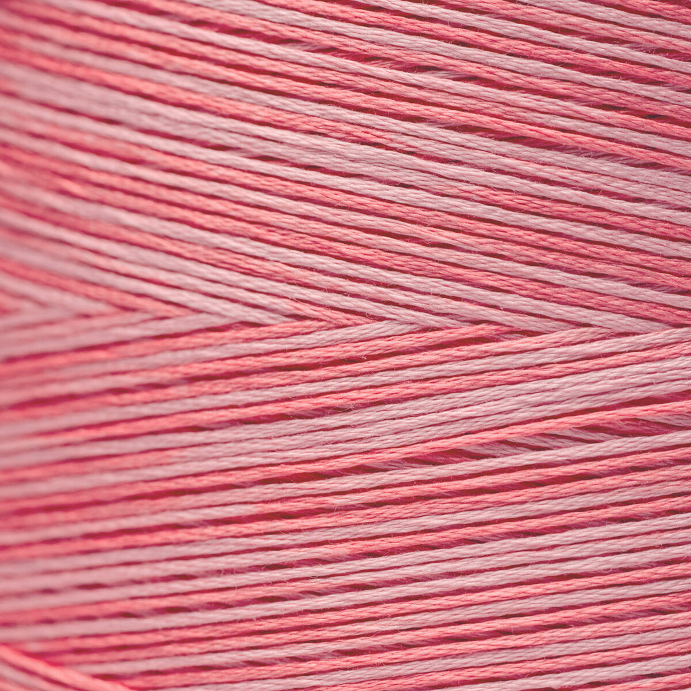 A close-up texture shot of pink and white yarn wound tightly, showing the fine strands and chevron pattern.